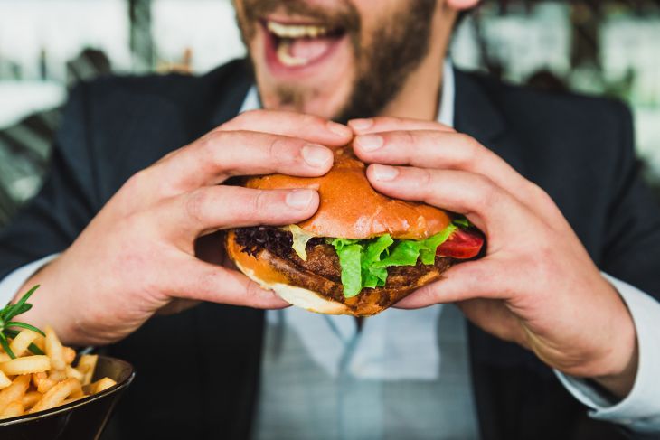 Mann mit snackable Burger in der Hand